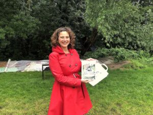 wethouder Marieke v Doorninck met boek Volkstuinverhalen op Amstelglorie